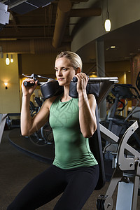 在健身房工作的女人照片中年身体素质运动机力量娱乐重量成人女士女性背景图片