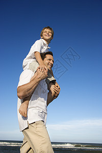 爸爸的肩膀上带着儿子男人青春期男性父亲假期男孩男子成人女孩中年人图片