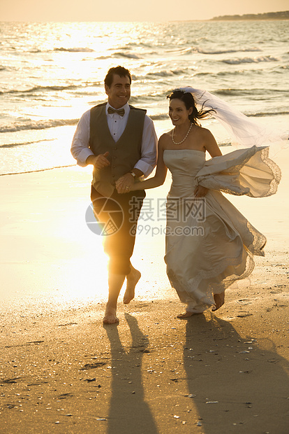 海滩上的新娘和新郎婚礼男子婚纱夫妻中年女性支撑两个人婚姻海岸图片