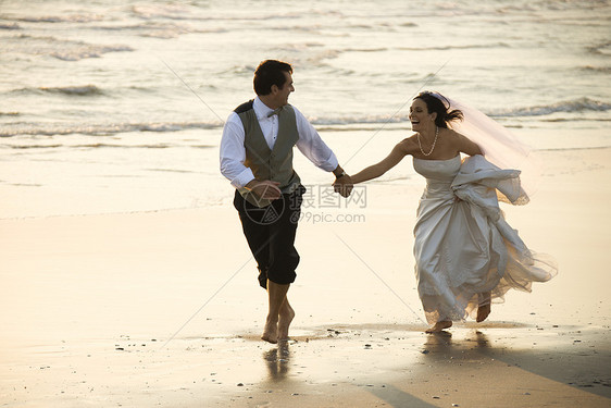 海滩上的新娘和新郎女性乐趣中年微笑婚礼婚纱照片两个人支撑海岸图片