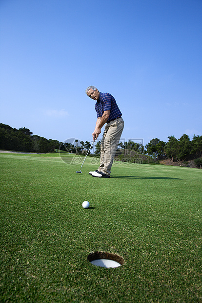 男人打高尔夫球照片中年运动娱乐闲暇推杆男子图片