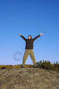 年轻人在山上跳高运动员男性男人假期喜悦天空蓝色空气自由活动图片