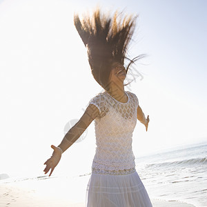 女人跳跃海岸中年自由双臂正方形头发女性照片海滩背景图片