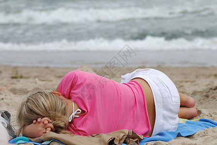 在海滩上娱乐假期女士说谎海岸线背景图片