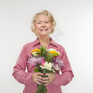 女人拿着花束观众成人微笑花朵眼神女性女士背景图片