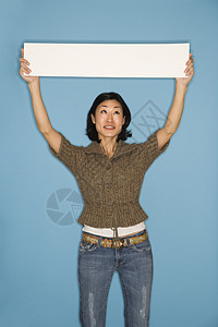 女人拿着空白的牌子中年人符号蓝色女士广告微笑图片