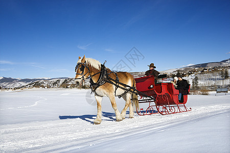 骑雪橇中年女士男性旅行运输享受气候成人假期乐趣图片