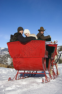 冬天骑雪橇夫妻三个人气候乐趣男性运输男子帽子成人享受图片