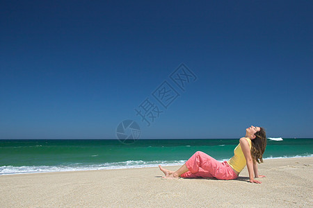 美丽的年轻女孩在沙滩上放松女性太阳喜悦热带阳光乐趣灵魂天空运动蓝色图片