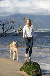 女人走路狗活动金发女郎闲暇遛狗海岸动物犬类宠物金发海滩图片