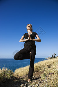 妇女练瑜伽支撑中心悬崖专注旅行双手心脏女士娱乐海岸图片