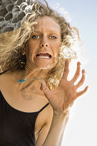 女人做脸手势岩石倾斜低角度女性中年头发金发中年人金发女郎图片