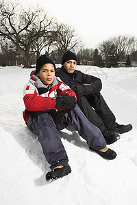 男孩们坐在雪地里男生朋友兄弟青春期友谊男性照片青少年外套两个人图片