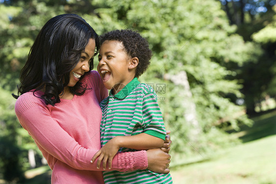 微笑的母亲和儿子公园妈妈肩膀女士男生眼神乐趣两个人女性青年图片