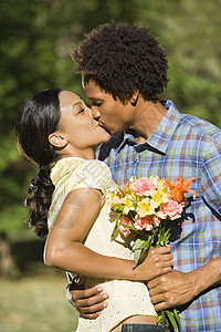 亲吻情侣微笑成人女性男人男性公园花朵女士花束女朋友图片