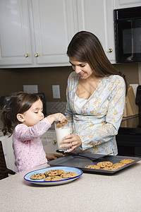 母亲和女儿女孩食物帮助烹饪童年青年糖果牛奶父母女性图片