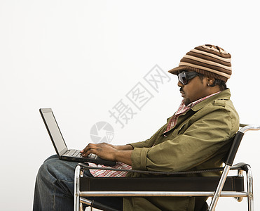 男人在笔记本电脑上水平男性中年人上网成人技术针织帽帽子椅子照片图片