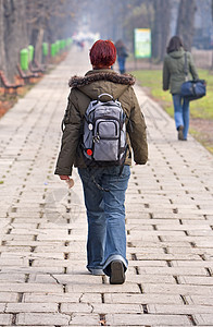 少女步行进步女孩女性风衣大学红发牛仔裤公园青少年女性化图片