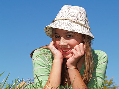 少女躺在草地上帽子女孩女士成人青少年休息快乐阳光女性图片