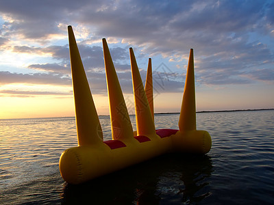 日落时水上更亮的可充气玩具背景图片