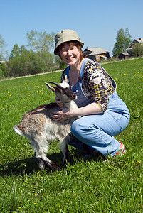 女农和年轻山羊小山羊决斗乡村牧场孩子们动物哺乳动物草地农业农场图片