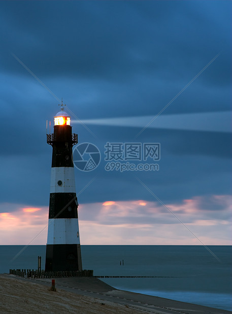 黄昏中的灯塔支撑解决方案海岸信仰报酬海滩岩石罗盘海岸线安全图片
