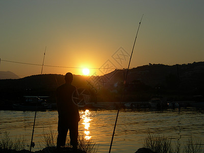 人在日落时钓鱼图片