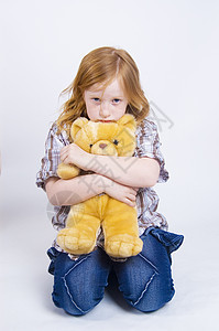 悲伤的女童孩子情绪青年红发女孩玩具熊背景图片