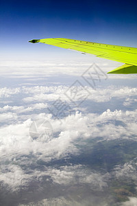 平面侧翼从左舷洞看旅行航空航班舷窗喷射运输天空技术高度蓝色背景图片