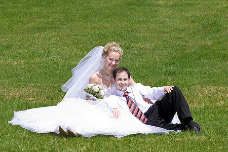在草地上新婚夫妇的其余配偶图片