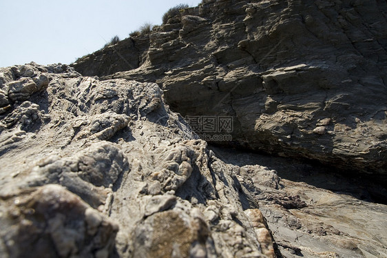 在地中海沿岸的岩石上海滩废墟支撑陷阱利润石头喘息假期图片