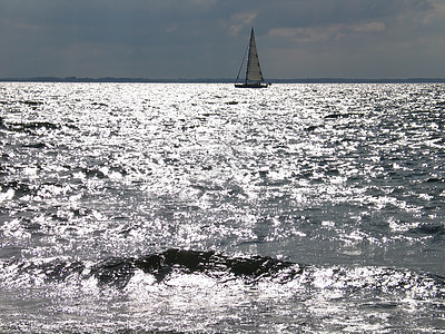 日落时乘帆船水手气候天空航行海岸线地平线太阳场景假期海洋图片