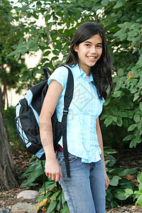 背着背包站在树旁的少女女孩混血中学青少年精力学生晴天孩子背景图片