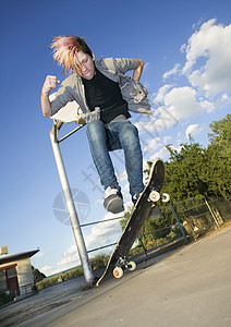 青少年滑板机运动青年诡计舌头牛仔裤头发男性滑板木板天空图片
