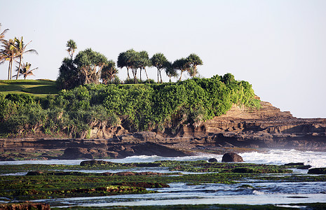 印度洋棕榈风暴山脉娱乐游客日落热带悬崖树木石头图片