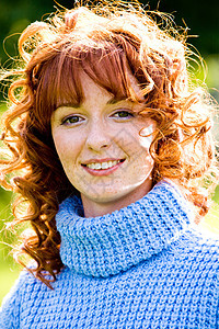 红头发年轻女性户外的亮丽肖像公园假期阳光城市红发场景运动衫卷曲城市生活雀斑图片