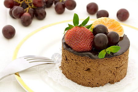 巧克力和水果蛋糕树叶反射水果桌巾奢华食物糕点叶子晚餐薄荷图片