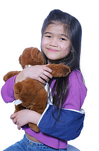 抱着娃娃的手臂折断的小姑娘拥抱童年玩具医疗微笑混血康复孩子吊带棕色图片