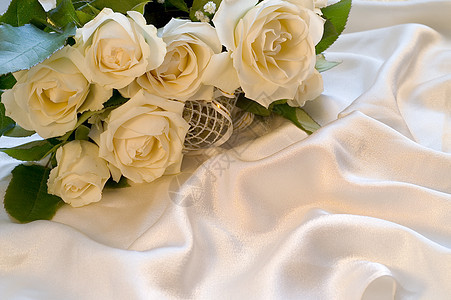 丝绸背景的白玫瑰玫瑰花瓣白色材料说谎丝带花束婚礼图片