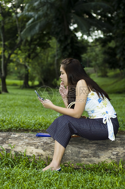 妇女与移动式坐在日志上的妇女图片