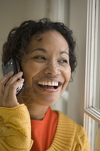 手机上的漂亮黑人女人细胞女性技术讲话沟通电话幸福微笑黑色通讯图片