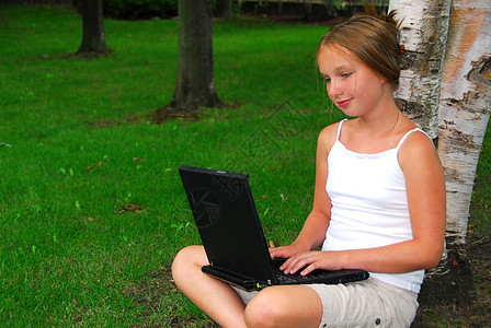 女孩计算机孩子孩子们青春期公园树木电脑青少年互联网技术冲浪图片
