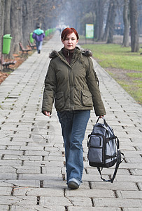 在秋天公园散步街道女性学生夹克女士女孩行人进步青少年公园图片