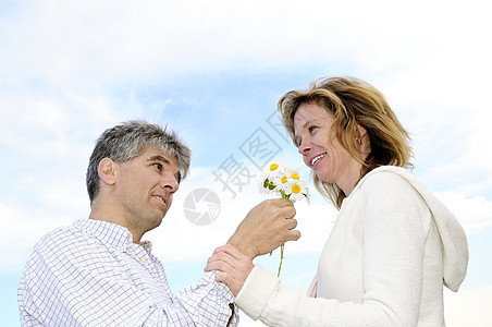 有鲜花的成熟浪漫情侣雏菊男人快乐妻子一代女士花朵乐趣喜悦婴儿图片