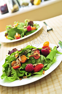 绿色沙拉加浆果和番茄餐厅节食盘子营养菠菜花园桌子美食倾斜午餐图片
