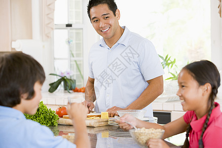 儿童在爸爸准备食物时吃早餐孩子们烹饪女儿蔬菜厨房男人家长父亲家庭青春期图片