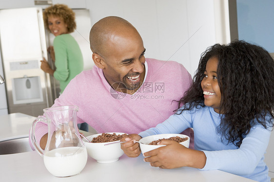 父亲和女儿一起坐着 就像他们与她一起吃早餐一样刀具享受三个人家庭厨房桌子男人食物微笑女士图片