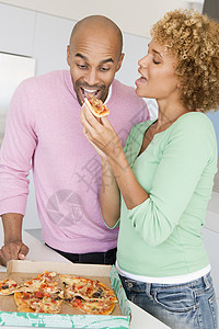丈夫和妻子吃披萨团结两个人服装男人享受休闲嘴巴饮食吃饭微笑图片