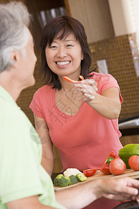 妇女向丈夫提供一块新鲜粉碎的辣椒图片
