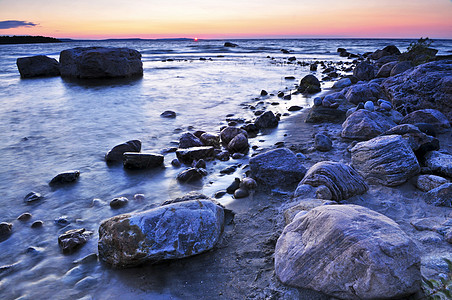 日落在水上太阳巨石海岸线反思环境公园波浪风景荒野湖岸图片